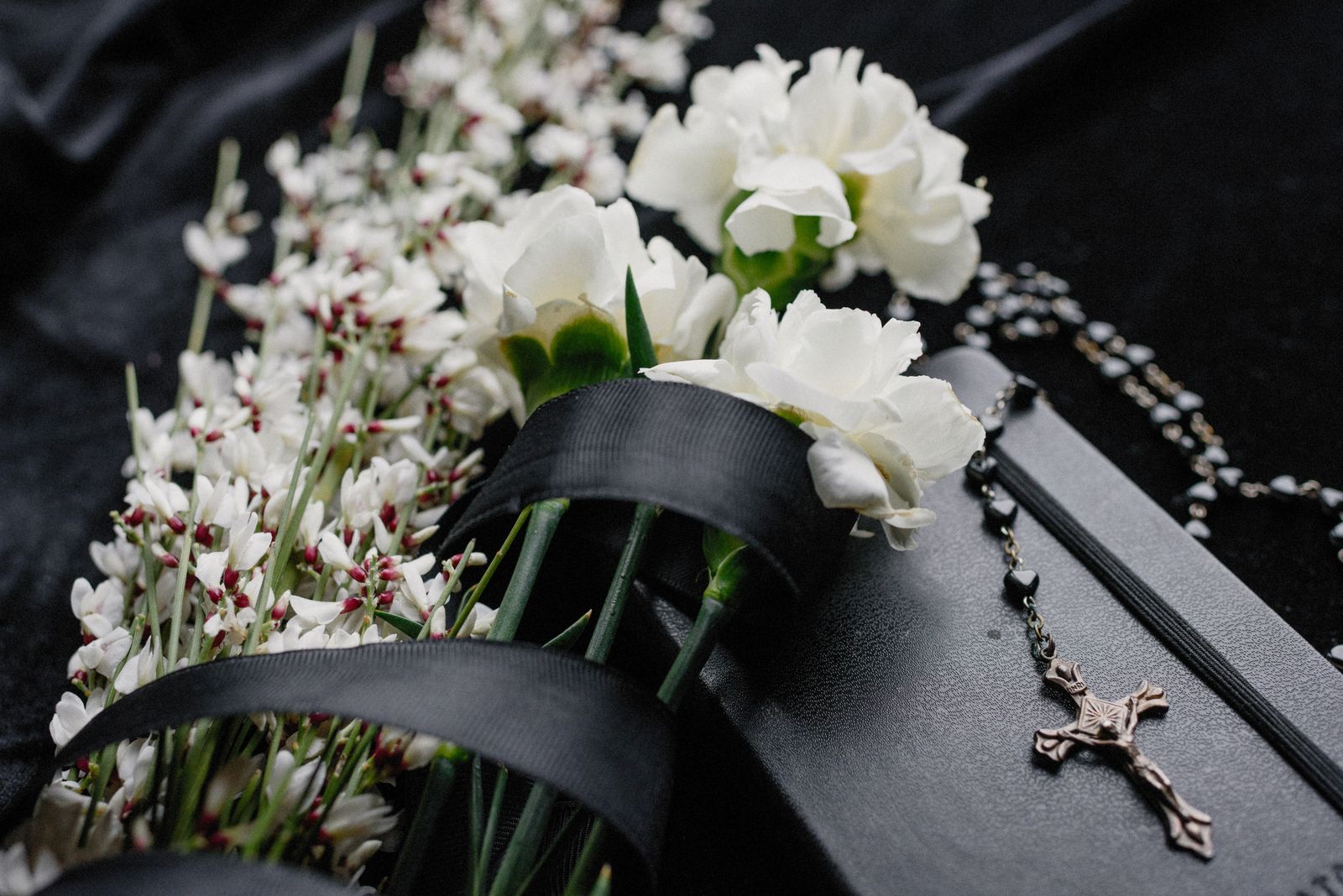 White memorial flowers on dark fabric