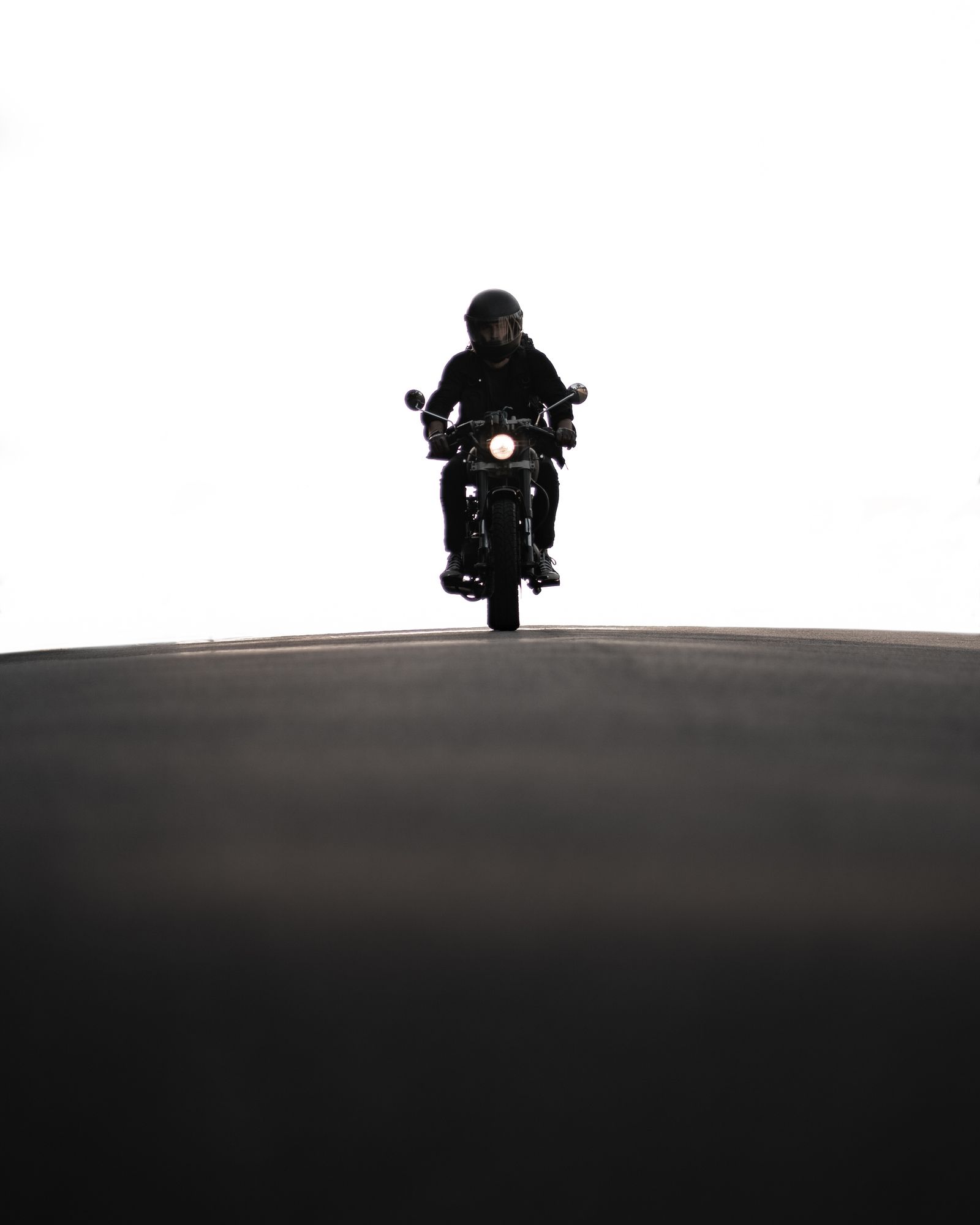 Helmeted motorcyclist riding at dusk