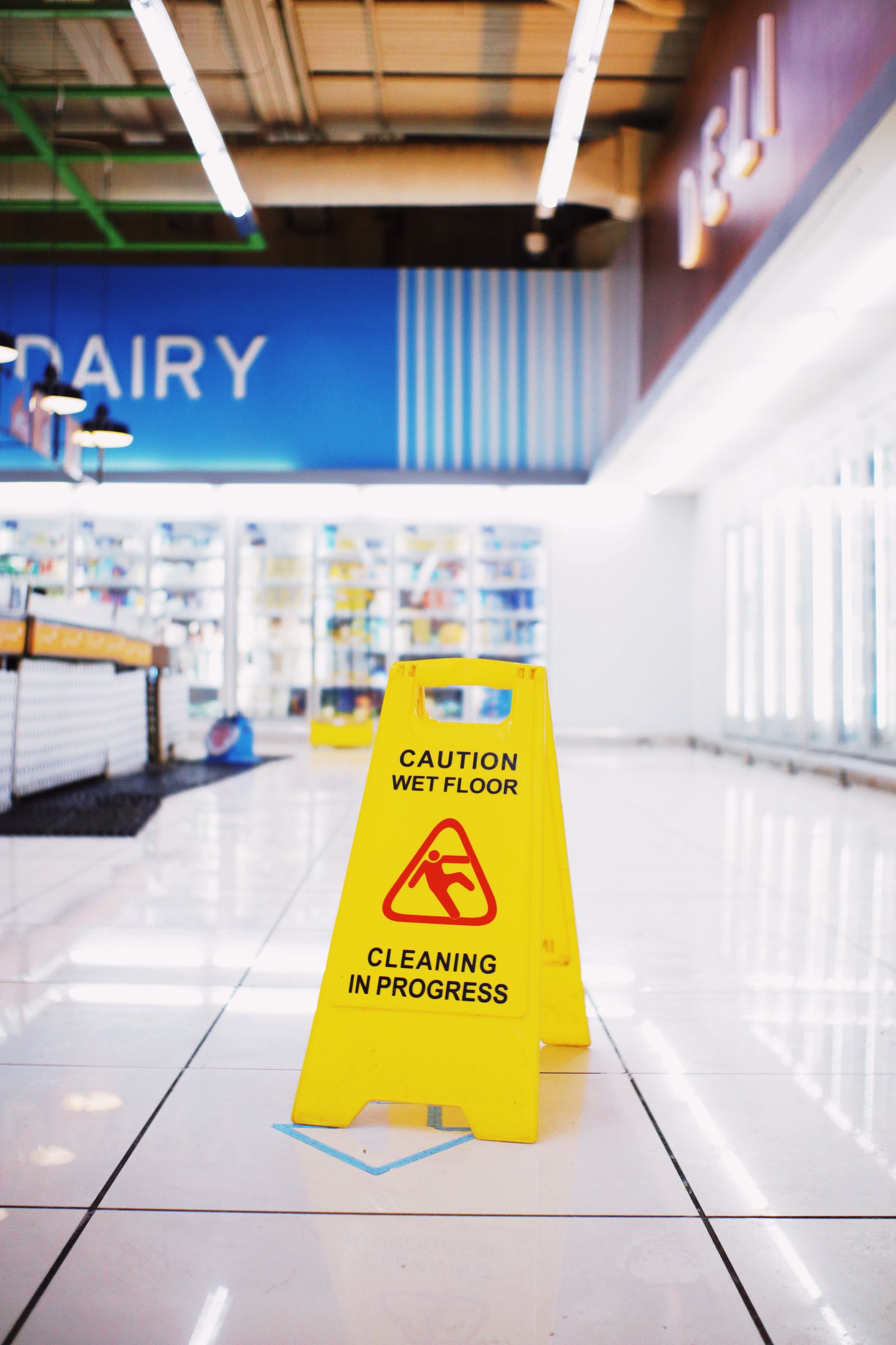 Wet floor caution sign in a supermarket aisle